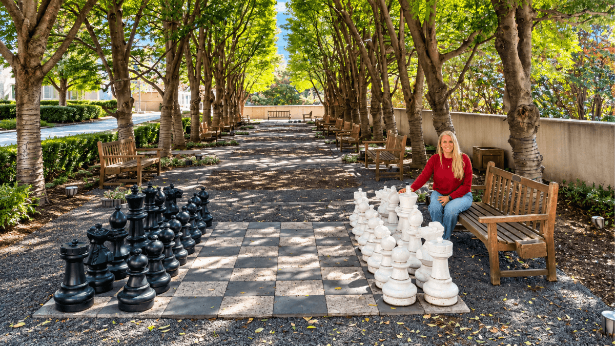 Oversized outdoor chess set beneath a tree-lined Dallas garden walkway, highlighting one of the hidden local experiences featured in a day exploring Dallas like a tourist
