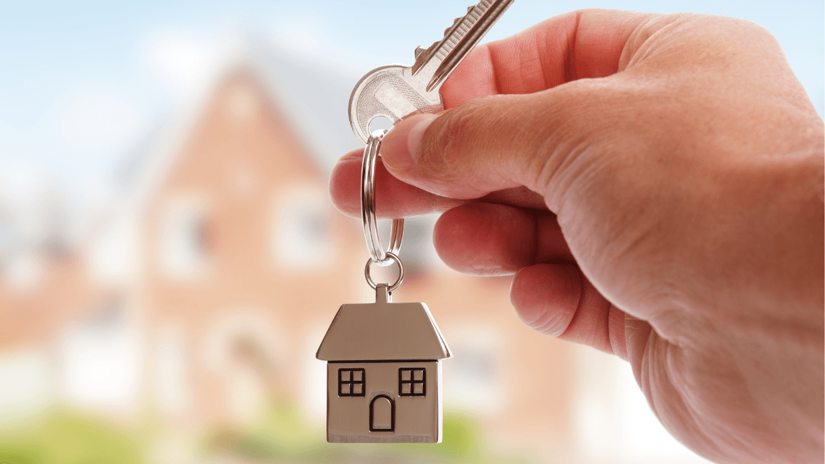House keys held in front of a home, representing the Texas home selling process from listing preparation and marketing through offers, contract, inspection and closing