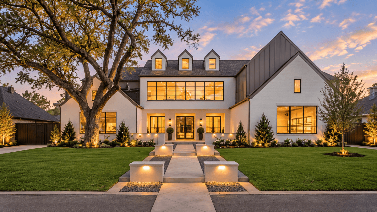Luxury North Dallas home at twilight with modern architecture, mature trees and warm interior lighting, illustrating the lifestyle and home styles buyers may find when purchasing in North Dallas