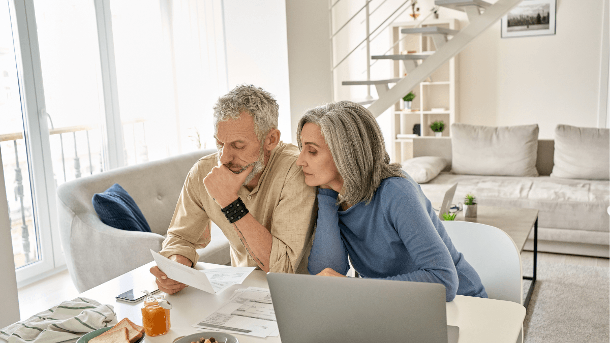 Home buyers reviewing real estate paperwork and a laptop, illustrating why working with a buyer’s agent can provide representation, negotiation and guidance when buying a home in Dallas
