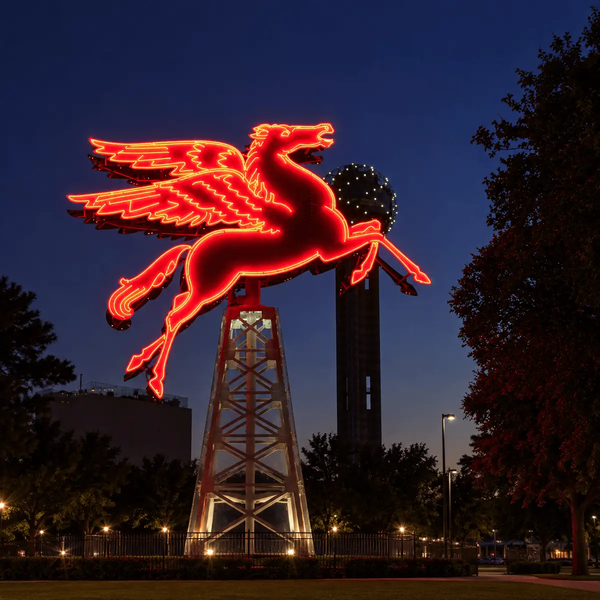 Historic neon Pegasus sign in downtown Dallas with Reunion Tower, reflecting Kelly Reber’s Dallas roots