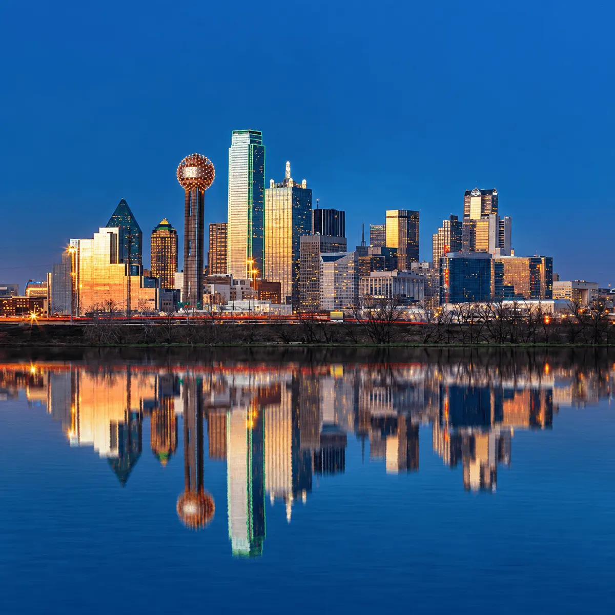 Downtown Dallas skyline reflected in the Trinity River, representing Kelly Reber’s Dallas real estate expertise