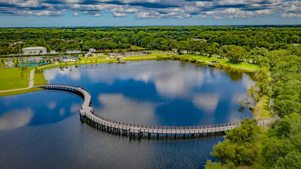 Timber pedestrian bridge at Carrollwood Village Park in Tampa FL over the lake, a serene community landmark