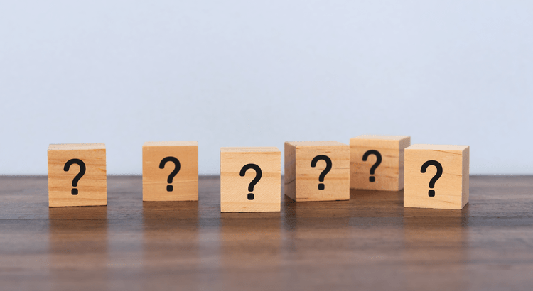 Question marks on wooden blocks symbolizing uncertainty about overbuilding in the North San Diego County housing market in 2025.