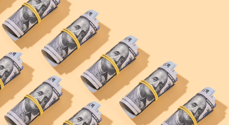 Rolled-up hundred dollar bills symbolizing home selling strategies, pricing, and market trends for sellers in San Diego County cities like Vista, Carlsbad, Escondido, San Marcos, Fallbrook, Bonsall, and Oceanside.