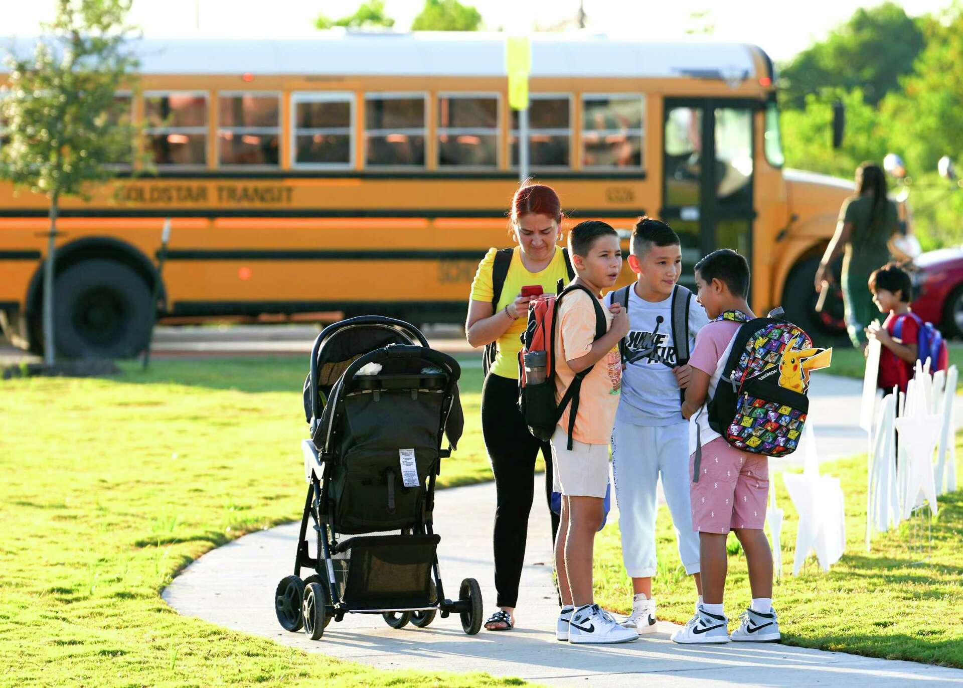 a photo of local katy isd students and families waiting for the bus, going to school
