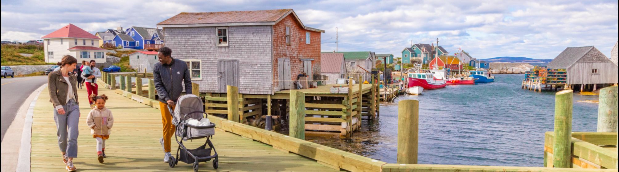 People walking along the Halifax waterfront boardwalk on a summer day