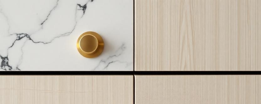 Macro detail of honed marble, brushed brass hardware, and white oak cabinetry textures.