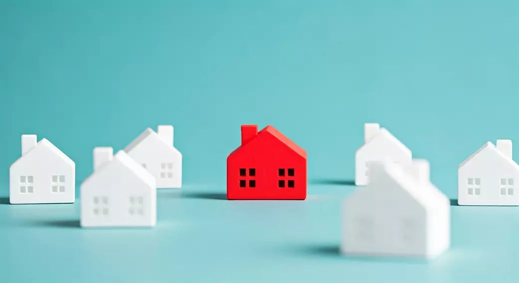 Red house standing out among white houses on blue background – real estate blog header image