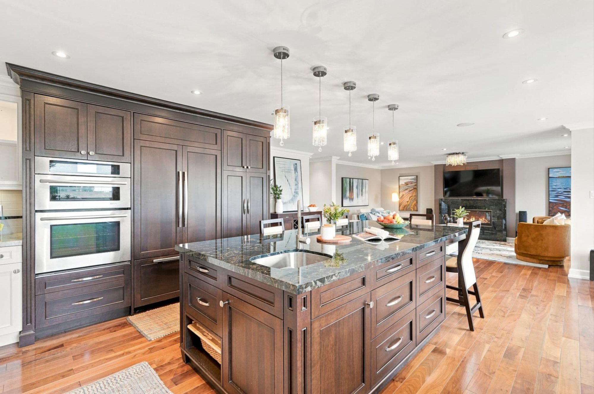 Gourmet kitchen with stainless steel gas range, mosaic tile backsplash, white cabinetry and built-in double ovens