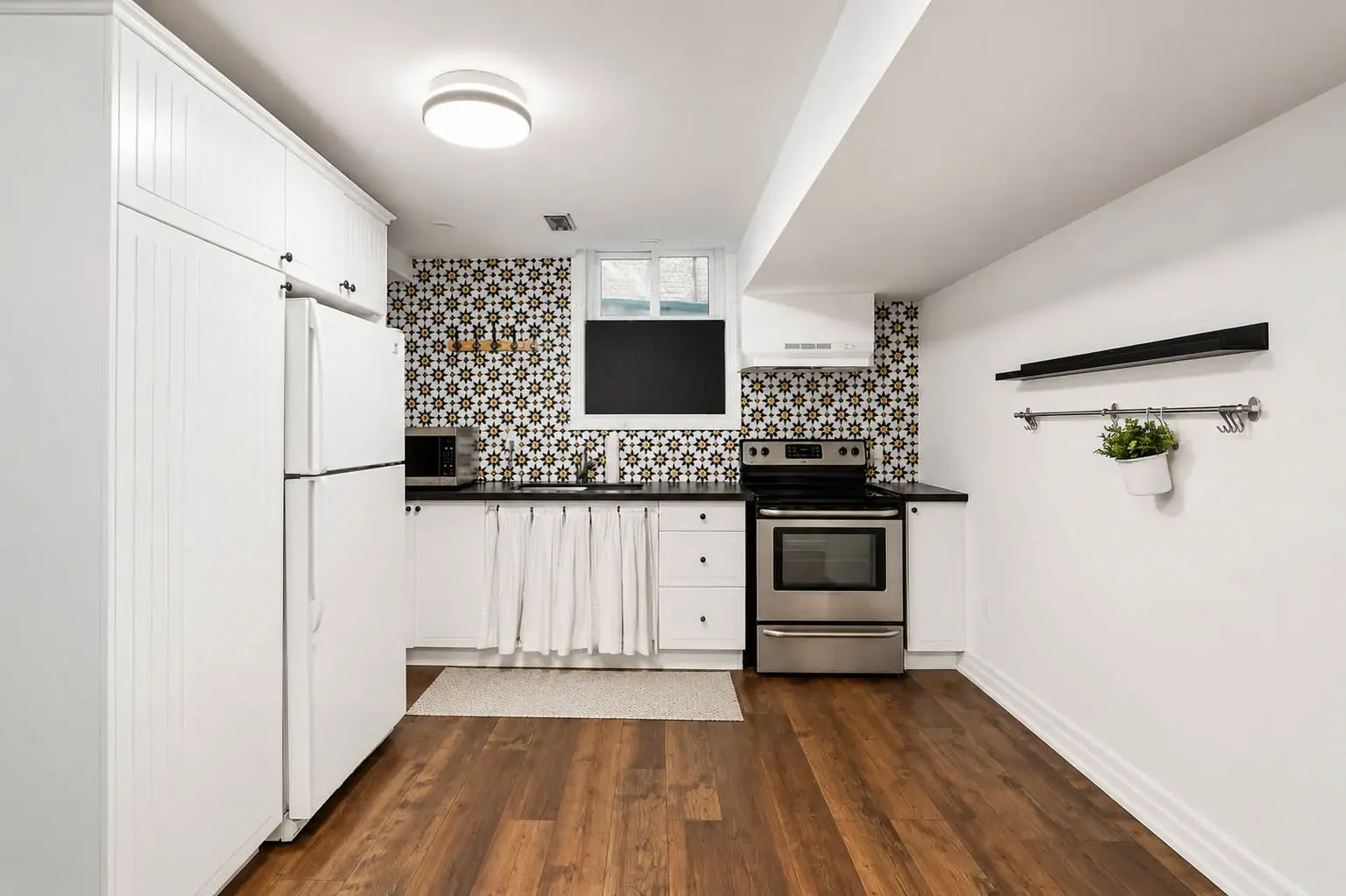 Lower-level kitchenette with white cabinetry at 816 Norwick Road