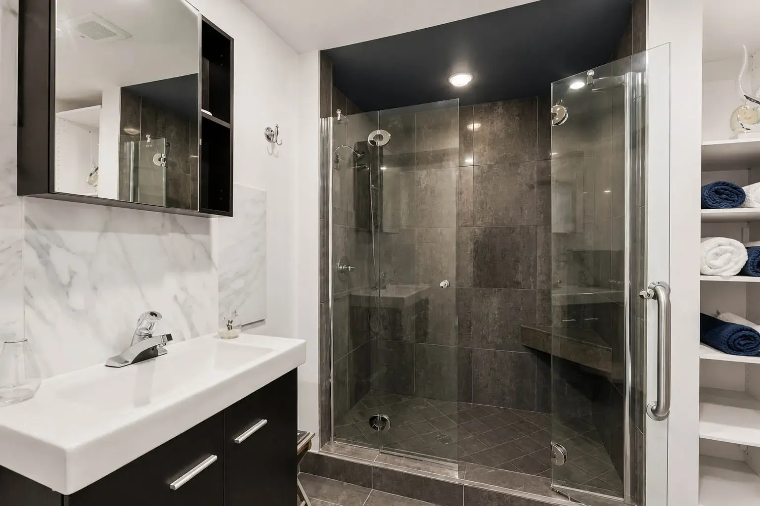 Lower-level bathroom with dark tiled glass shower at 816 Norwick Road