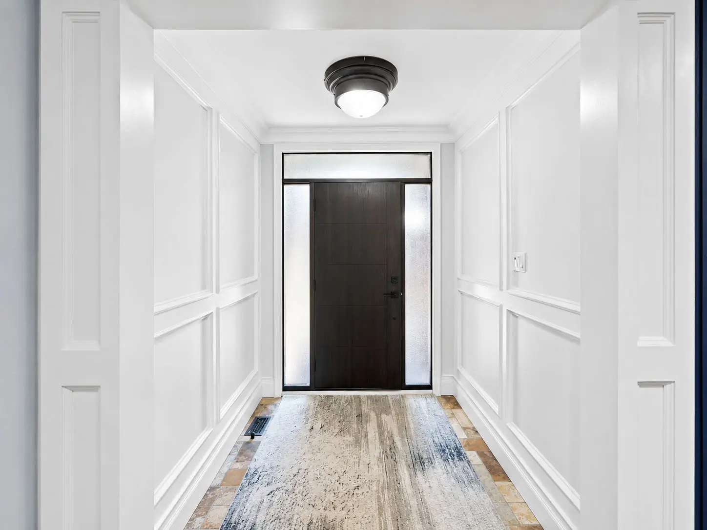 Bright front entry hallway with modern dark door at 816 Norwick Road