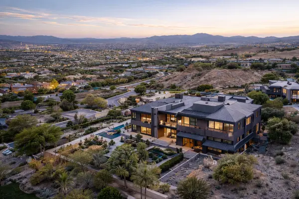 Aerial view of a modern luxury home in a desert hillside residential neighborhood