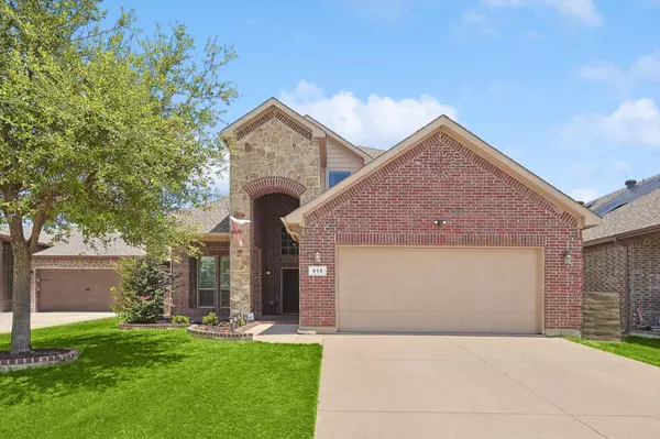Two-story brick and stone home with arched entryway, attached two-car garage, and landscaped front yard in a Fort Worth neighborhood.