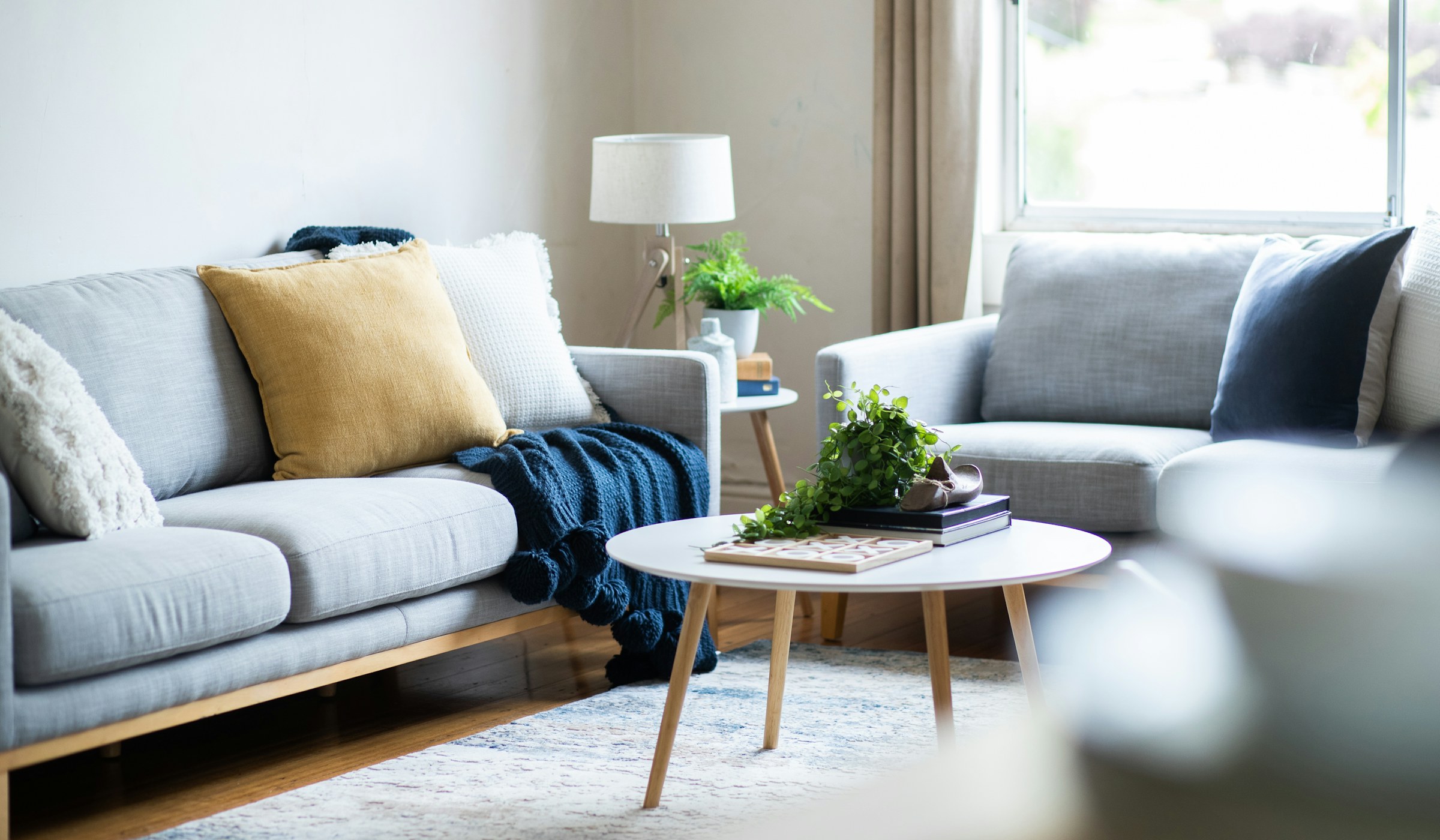 A sunlit living room with a sofa and a low coffee table