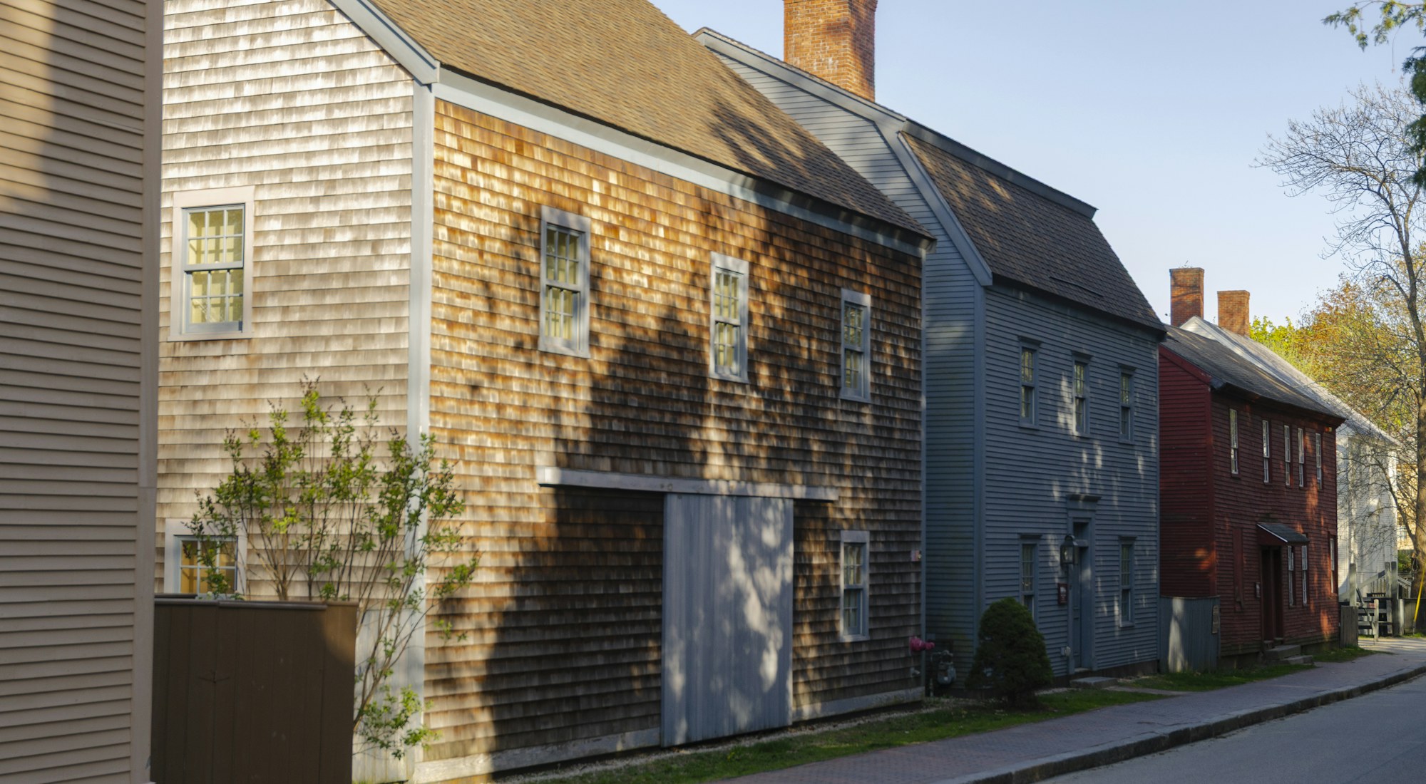 A row of wooden houses along a sunny residential street