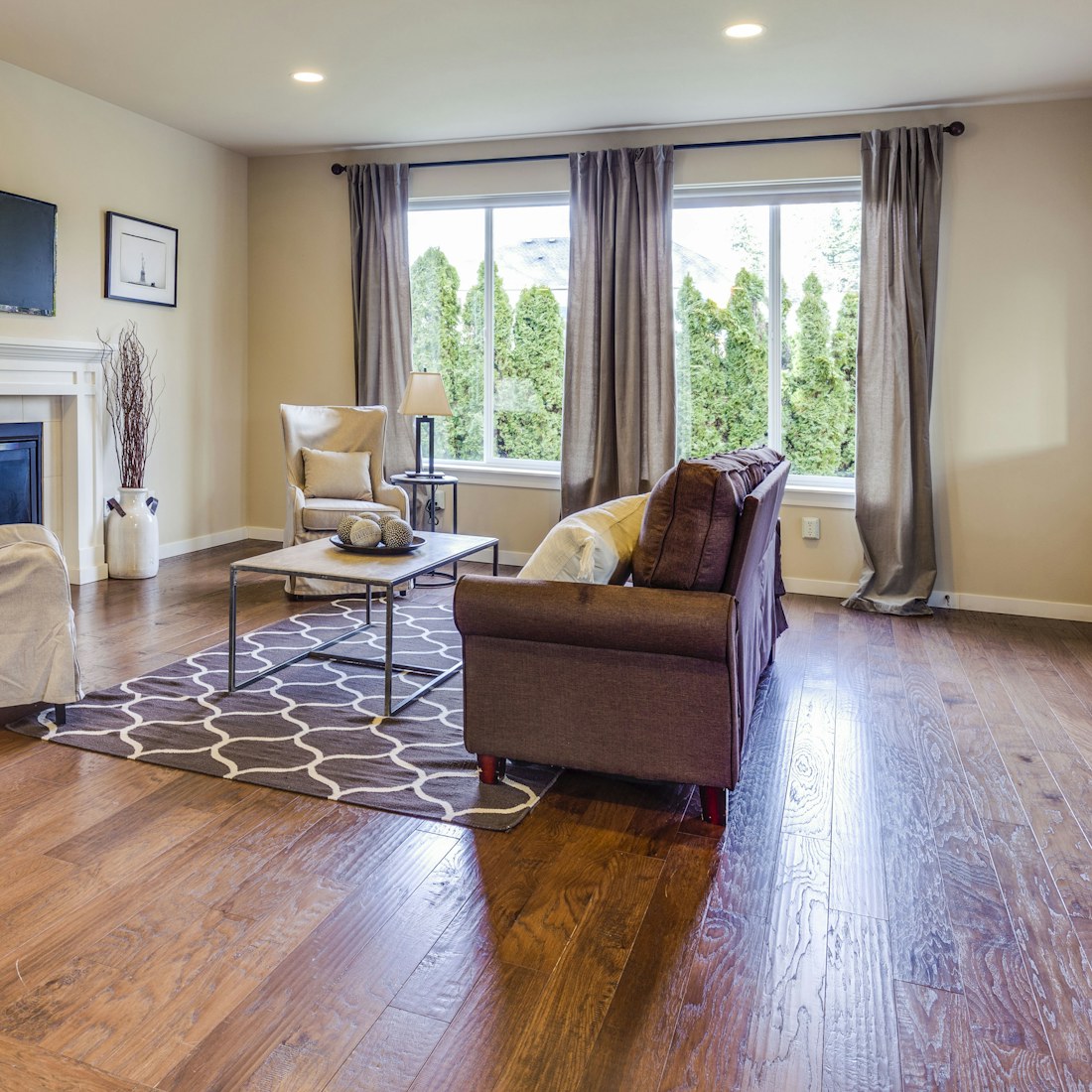 A tidy living room with seating arranged around a fireplace