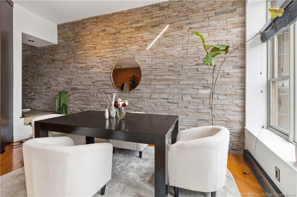 Dining area with stacked stone feature wall at 303-850 Main Street Moncton