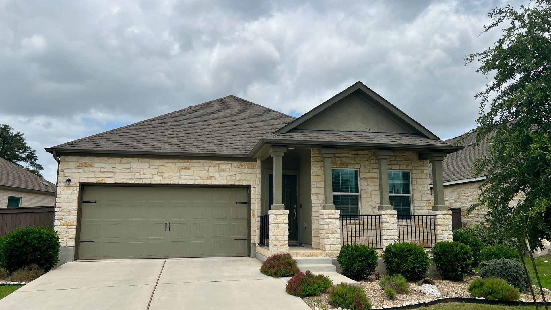 Bryson neighborhood home in Leander TX with stone accents, covered entry, and manicured landscaping