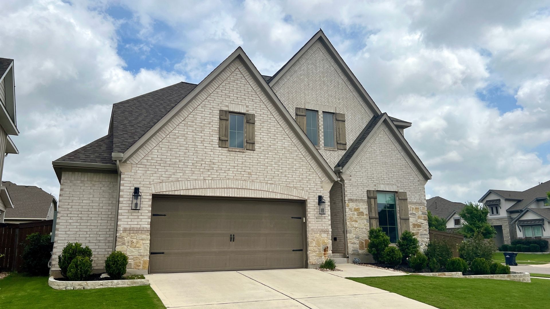 Home in the Bryson master-planned community in Leander TX with stone exterior and covered entry