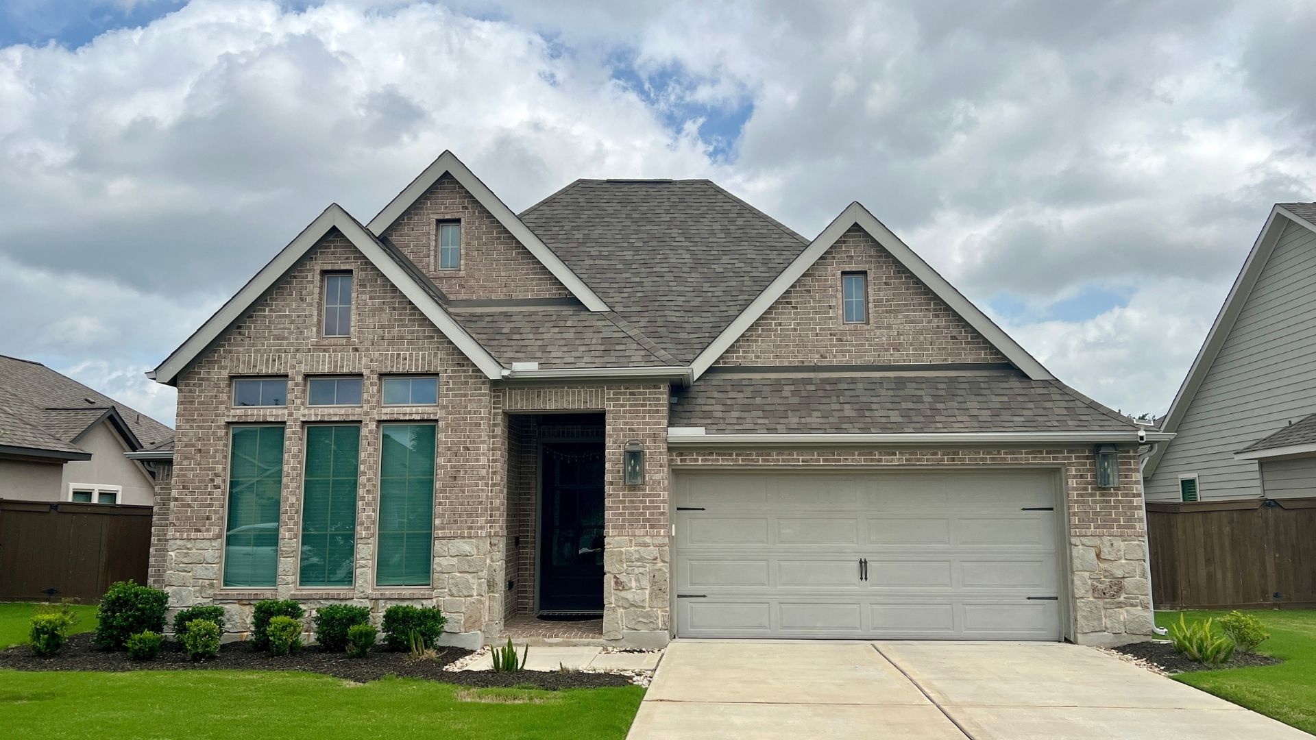 Mid-size home in the Bryson master-planned community in Leander Texas with suburban exterior design and landscaped front yard