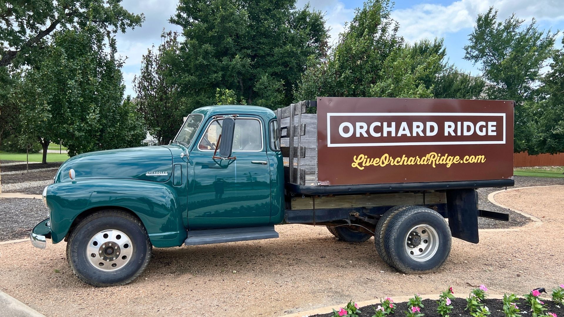 Vintage Orchard Ridge community truck display at the entrance in Liberty Hill Texas with landscaped surroundings
