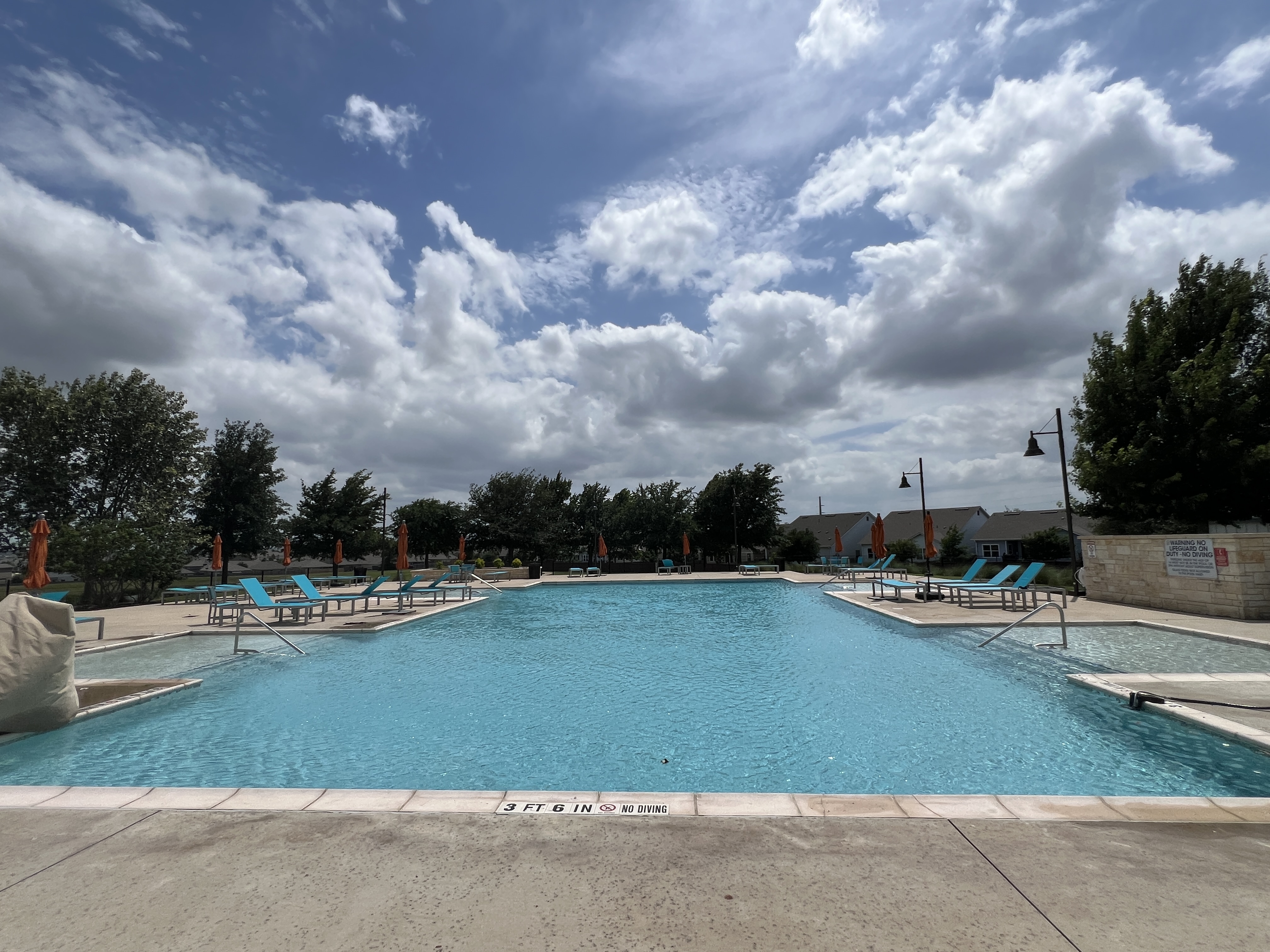 Resort-style swimming pool in Orchard Ridge Liberty Hill Texas with lounge seating and community amenity area