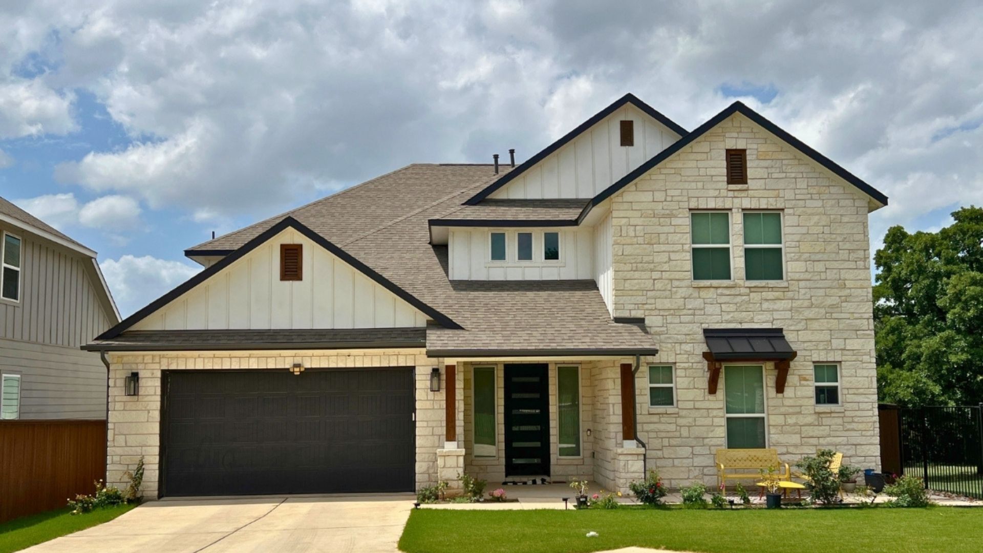 Large modern home in Orchard Ridge Liberty Hill Texas with stone exterior, covered entry, and landscaped front yard