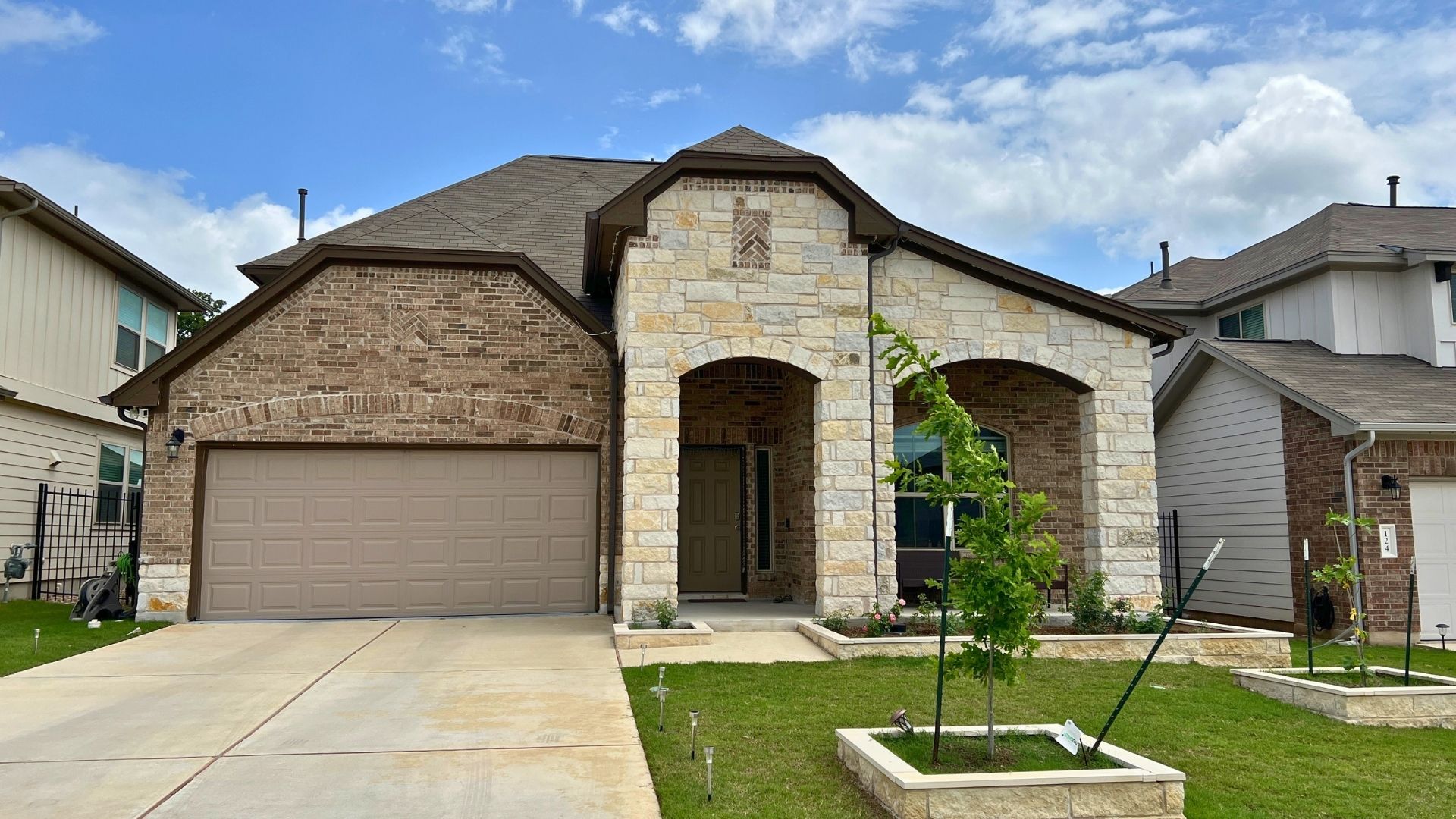 Larkspur Leander TX home with brick accents, front-entry garage, and mature landscaping