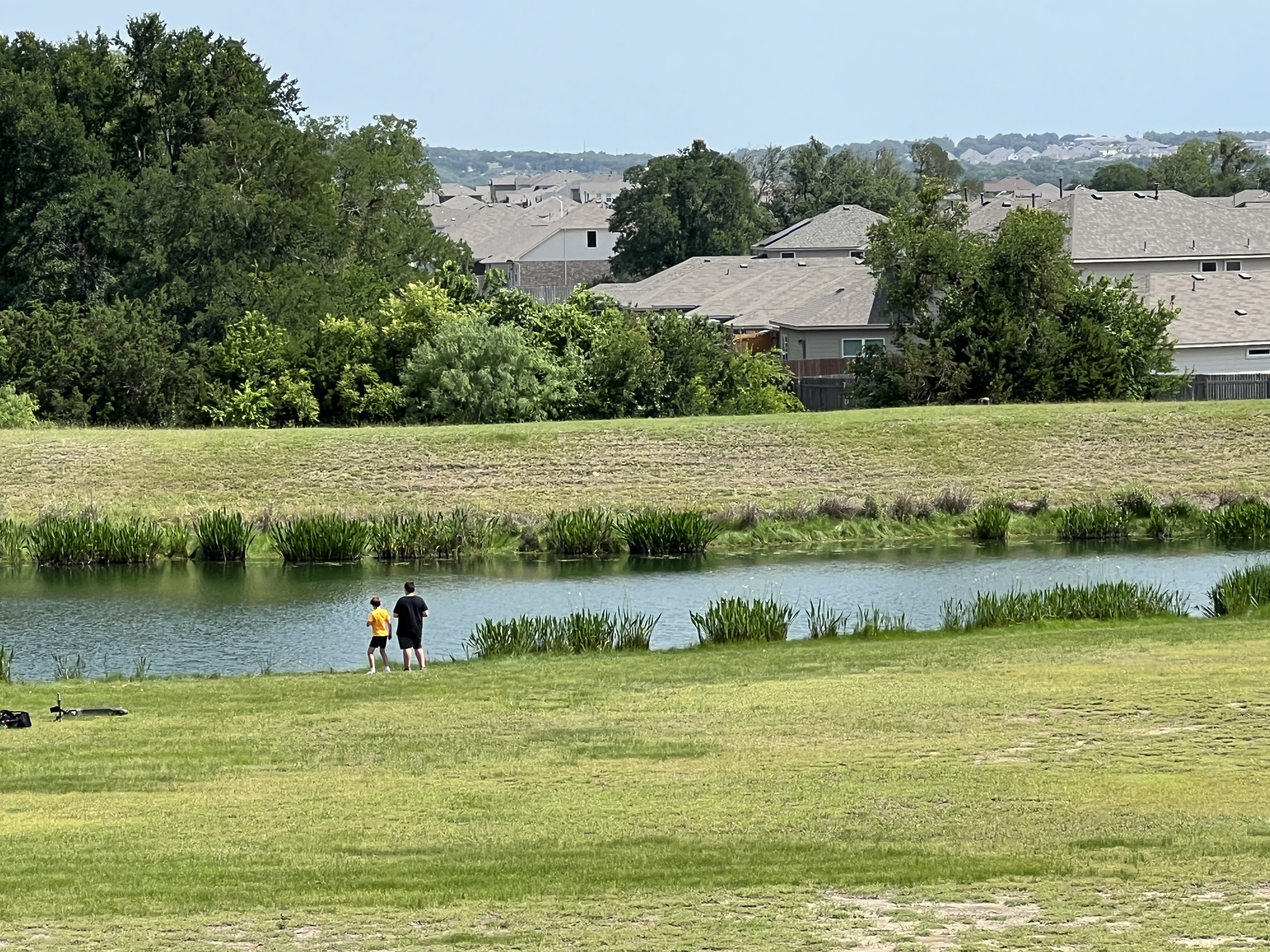 Fishing pond and open green space in Orchard Ridge Liberty Hill Texas with neighborhood walking areas and scenic community views