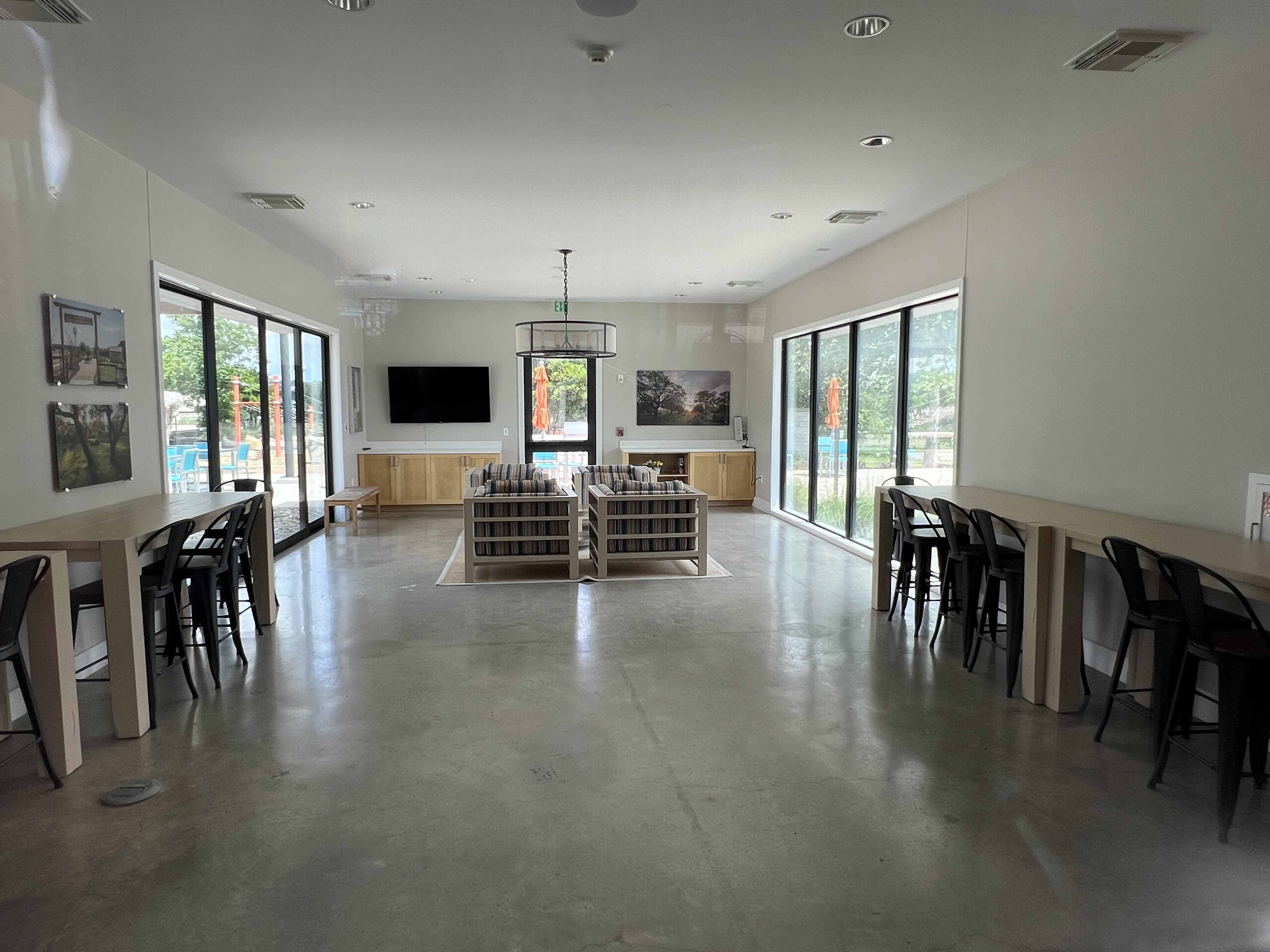 Interior of the Orchard Ridge clubhouse in Liberty Hill Texas with community lounge seating, gathering areas, and large windows overlooking amenities