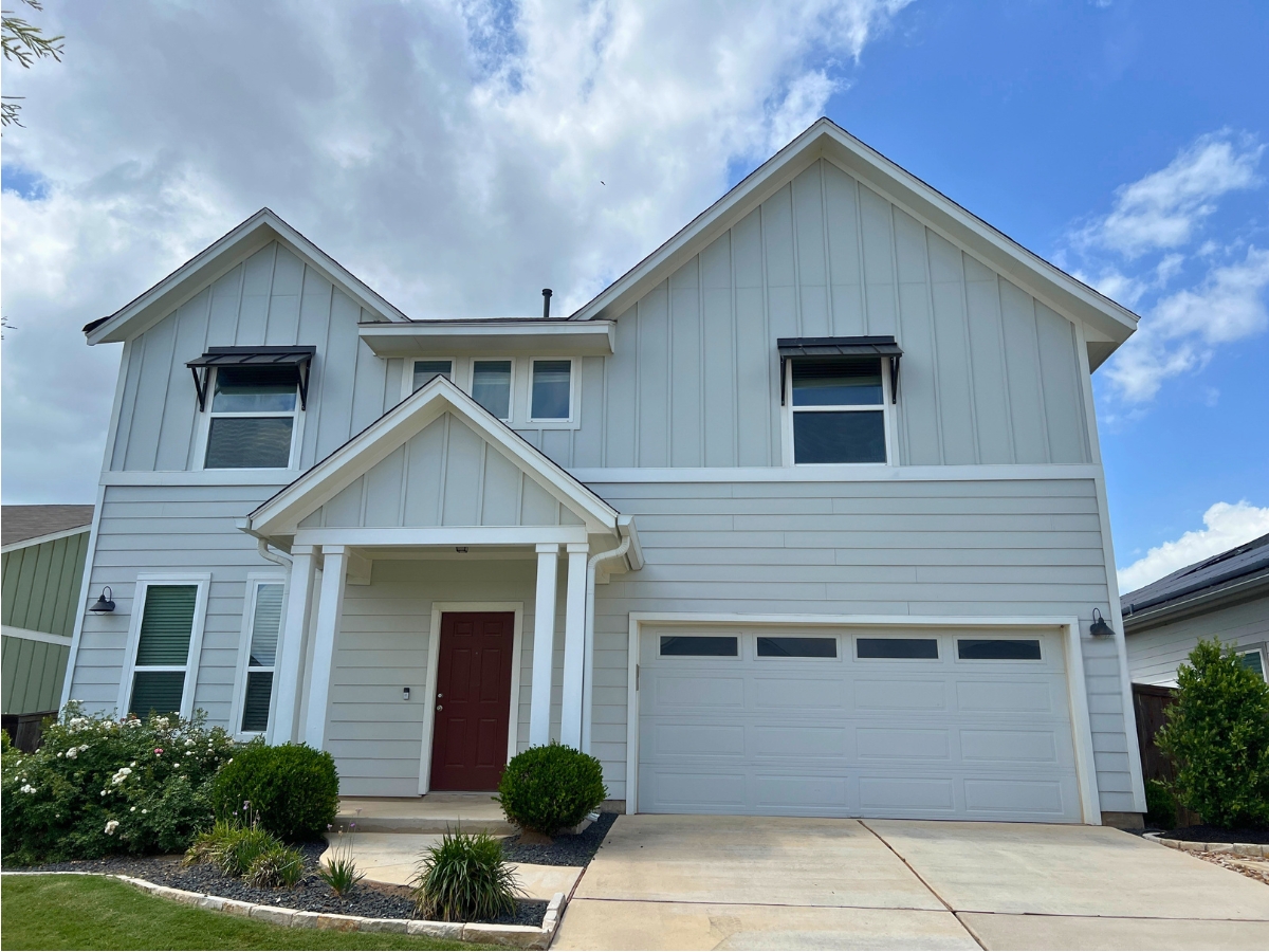 Two-story Orchard Ridge Liberty Hill Texas home with board-and-batten exterior, white trim details, and inviting covered porch