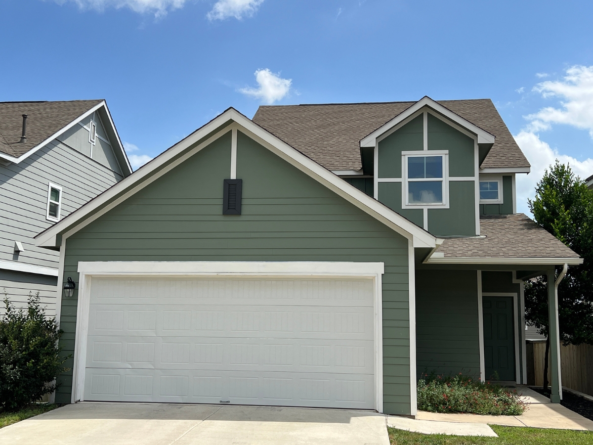 Two-story Orchard Ridge Liberty Hill Texas home with sage green siding, contrasting white trim, and suburban exterior styling
