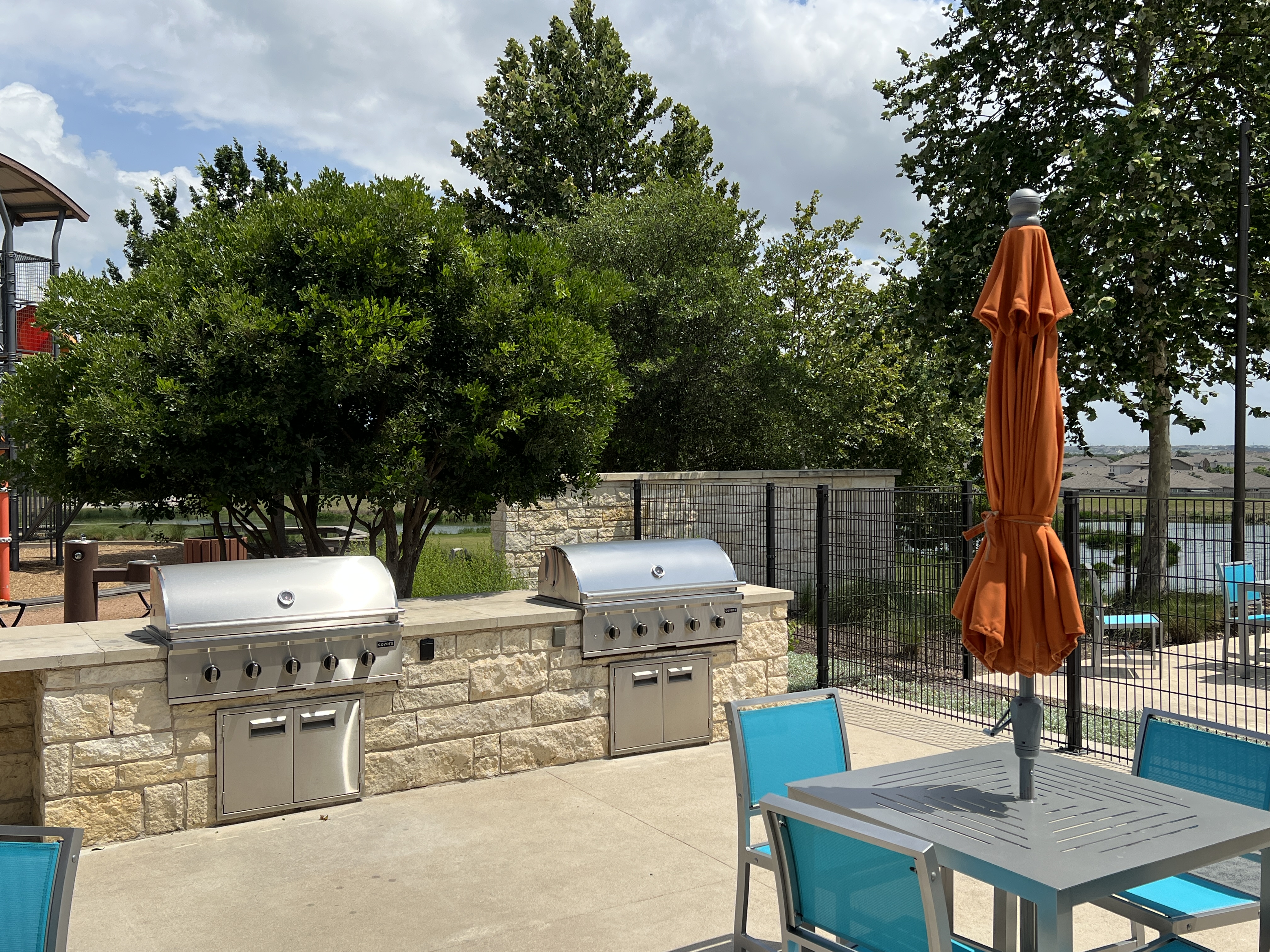 Outdoor grilling area at Orchard Ridge Liberty Hill Texas with community barbecue stations and poolside gathering space