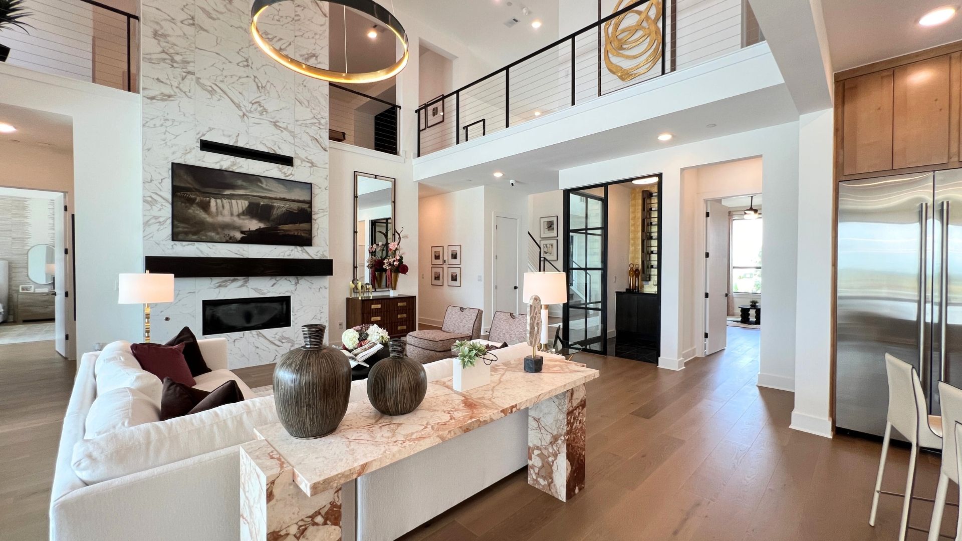 Two-story great room with floor-to-ceiling fireplace in the Drees McKennan model home at Hilltop Ranch in Leander, Texas