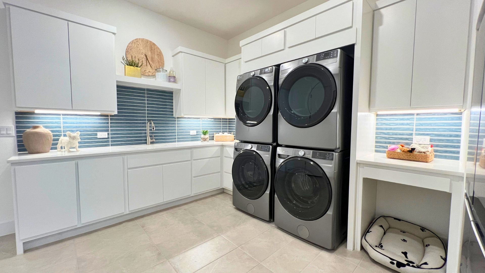 Oversized laundry room with space for two stacked washer and dryer sets in the Drees McKennan model home at Hilltop Ranch in Leander, Texas
