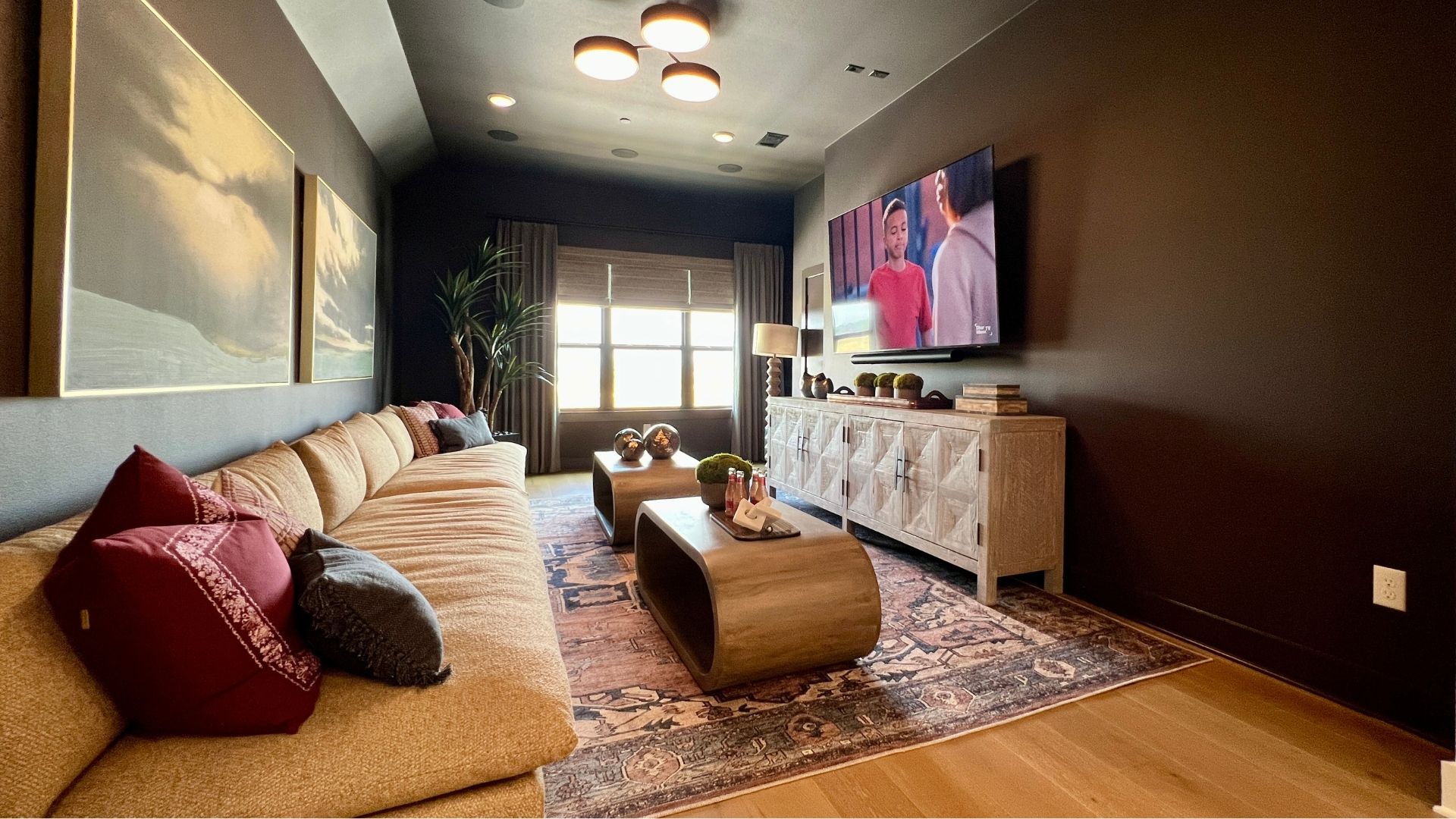 Media room with theater-style seating area in the Drees McKennan model home at Hilltop Ranch in Leander, Texas
