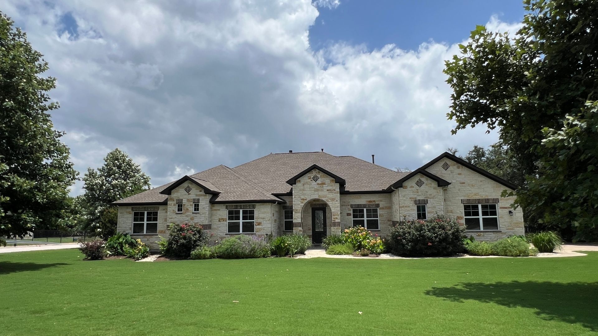 Greatwood streetscape featuring established homes and spacious one-acre lots in Leander, Texas