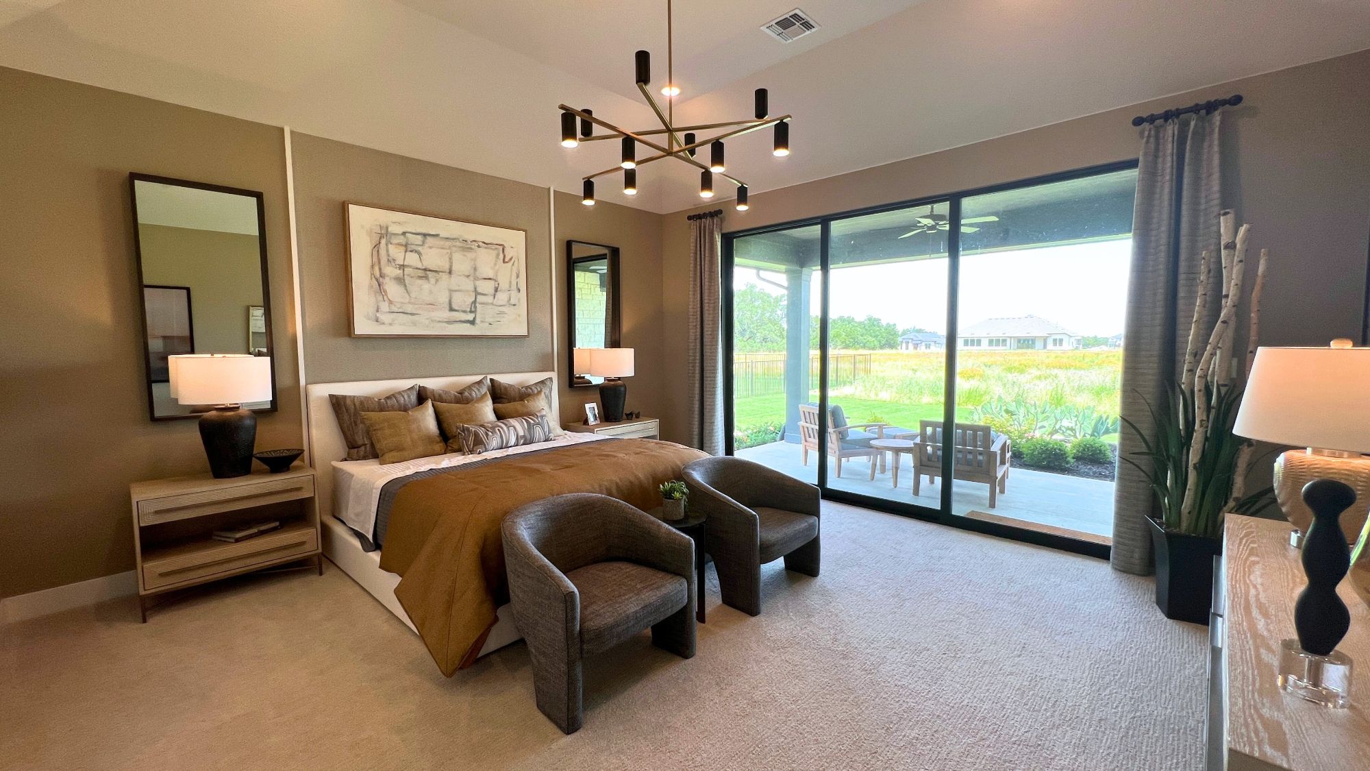 Primary bedroom with abundant natural light in the Scott Felder Bulverde model home at Leander Estates in Leander Texas