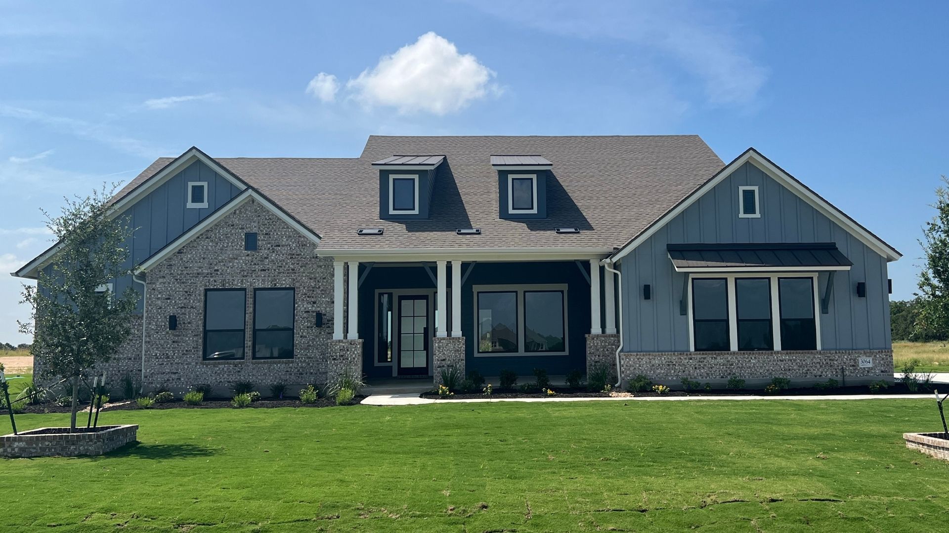 Modern farmhouse-style home in Leander Estates featuring brick and board-and-batten exterior design in Leander Texas