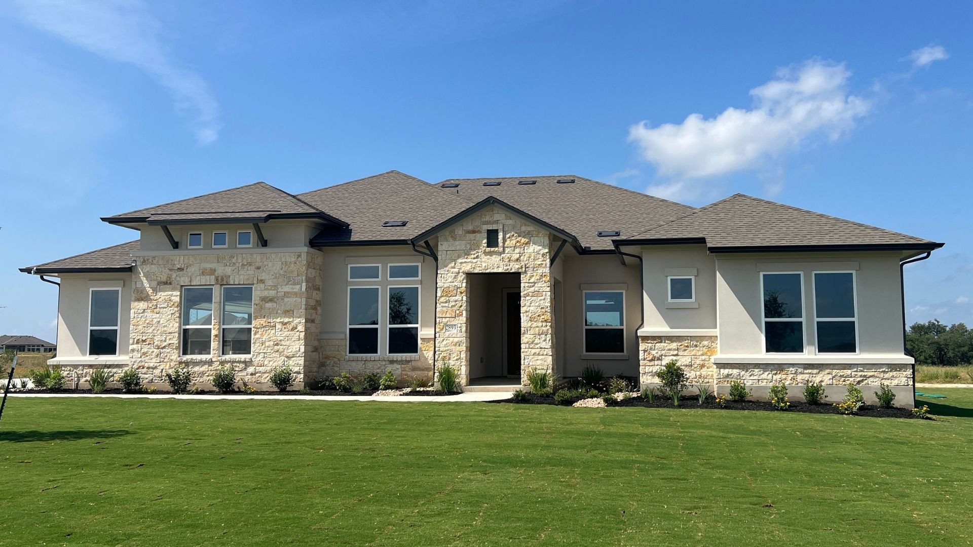 New construction luxury home in Leander Estates with stone exterior and spacious acre-lot setting in Leander Texas