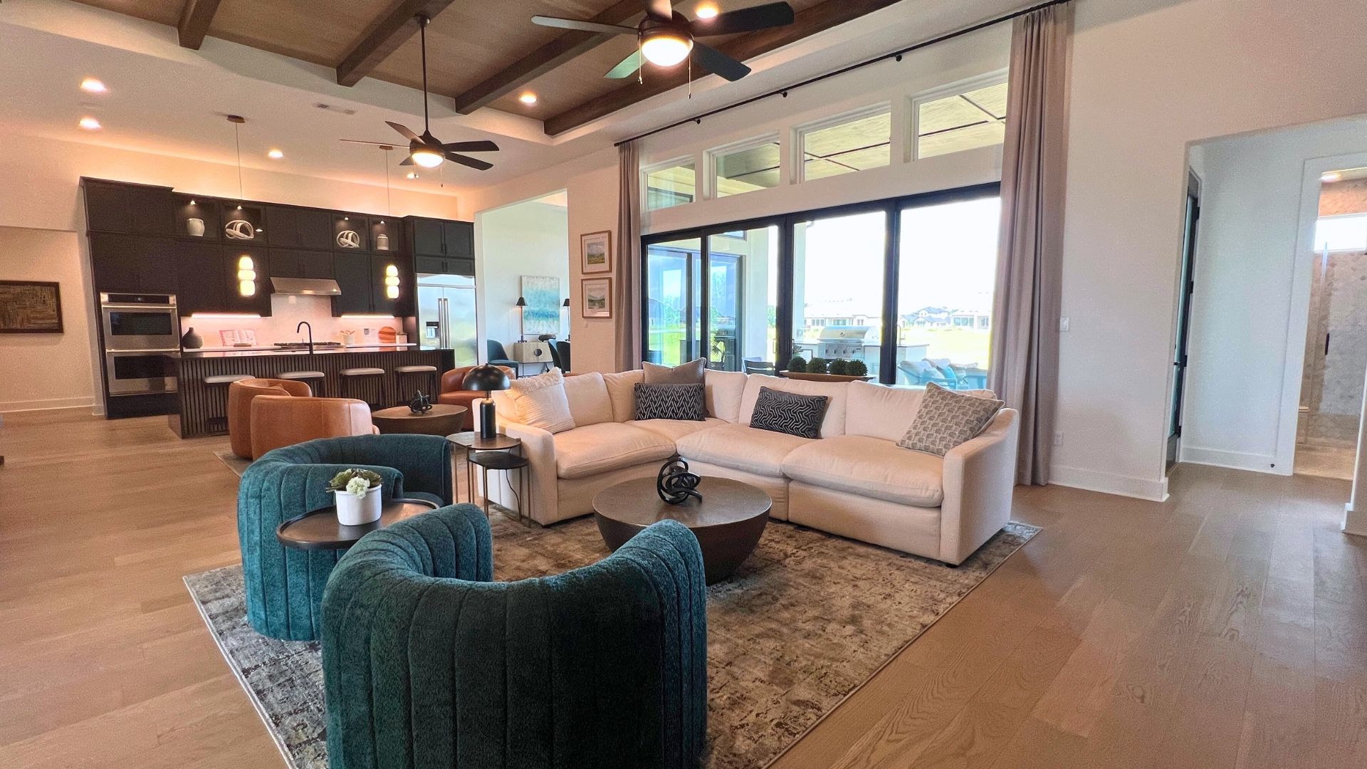 Open concept floor plan with living room, lounge area, and designer kitchen in the Giddens Kerrville model home at Leander Estates in Leander Texas