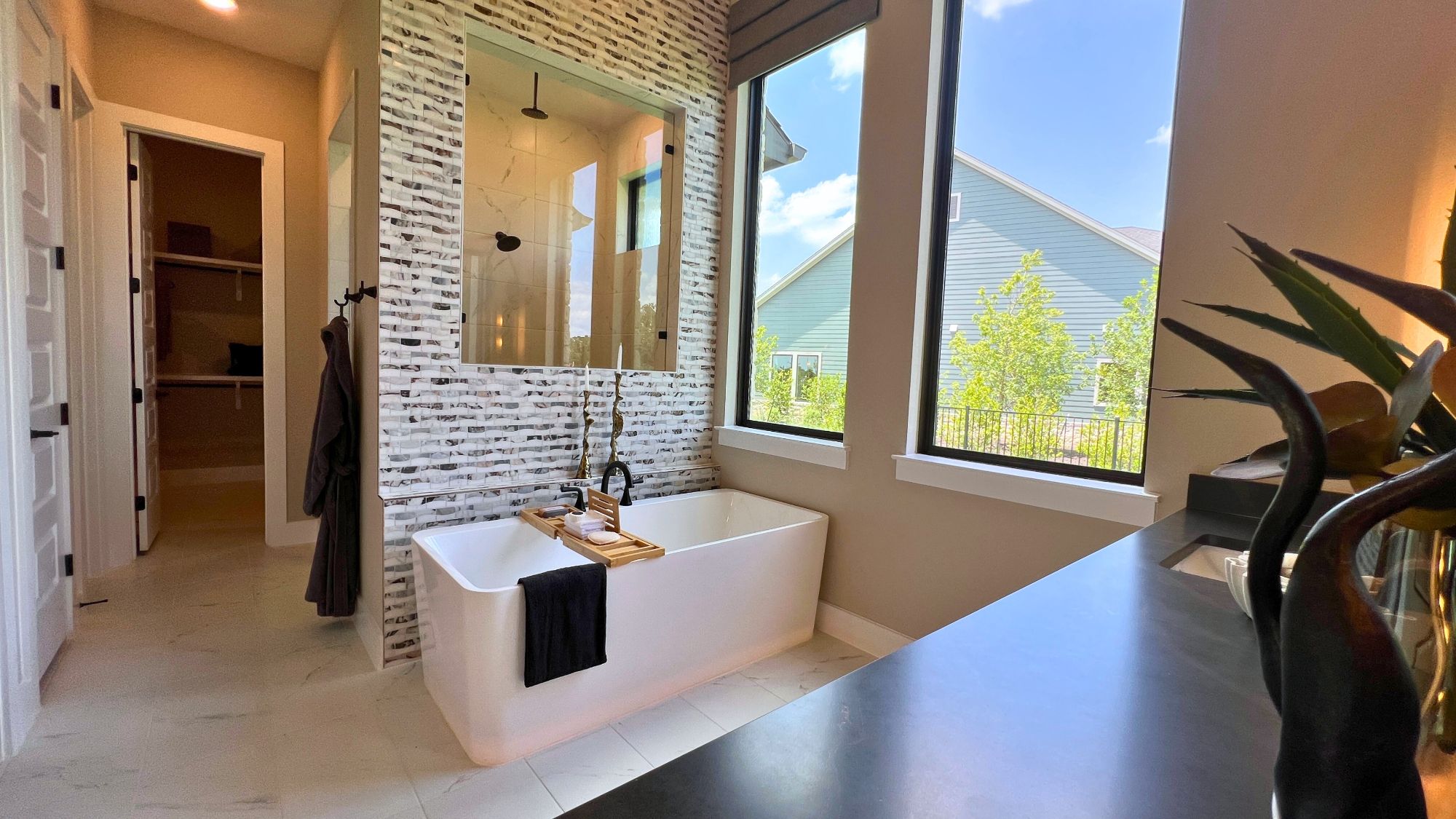 Luxury primary bathroom with walk-in shower and freestanding tub in the Scott Felder Bulverde model home at Leander Estates in Leander Texas