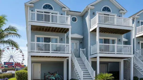 Typical blue Wildwood townhome with multiple balconies and parking, ferris wheel in background. Affordable Jersey Shore properties