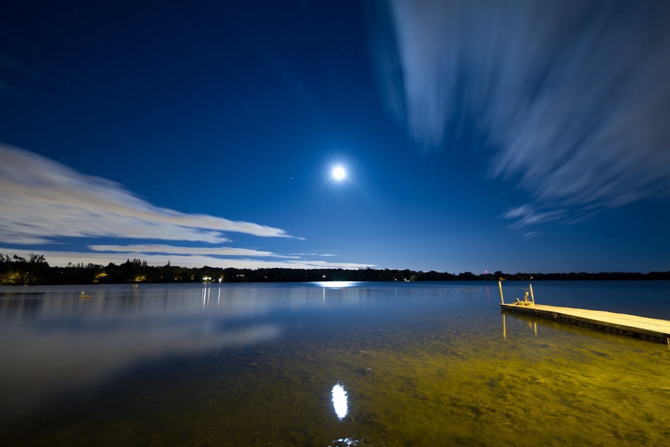 Lake Wilcox shoreline at night with moon over the water in Oak Ridges