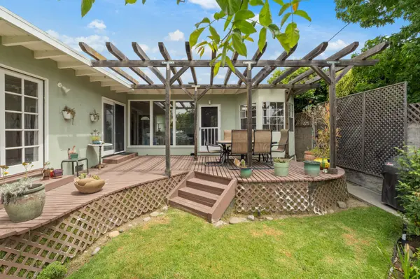 Backyard deck with a pergola and lawn at a family home being prepared for sale