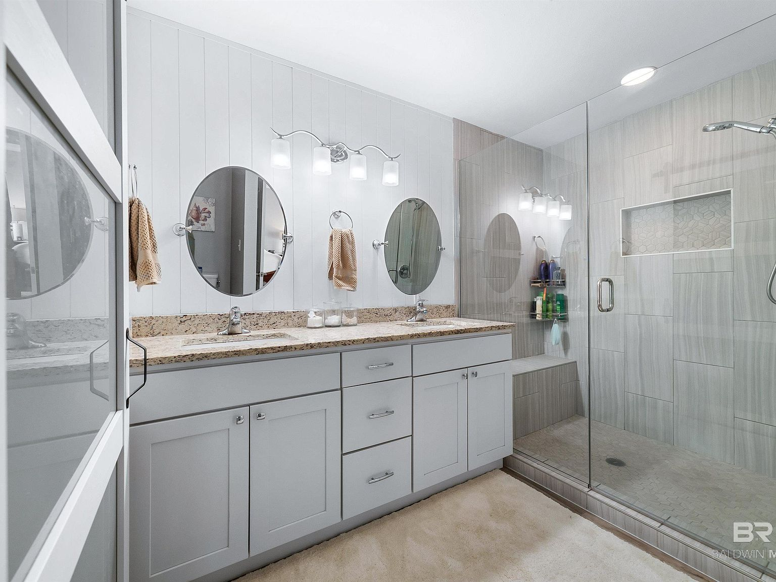 Renovated master bathroom with granite countertops and walk-in shower