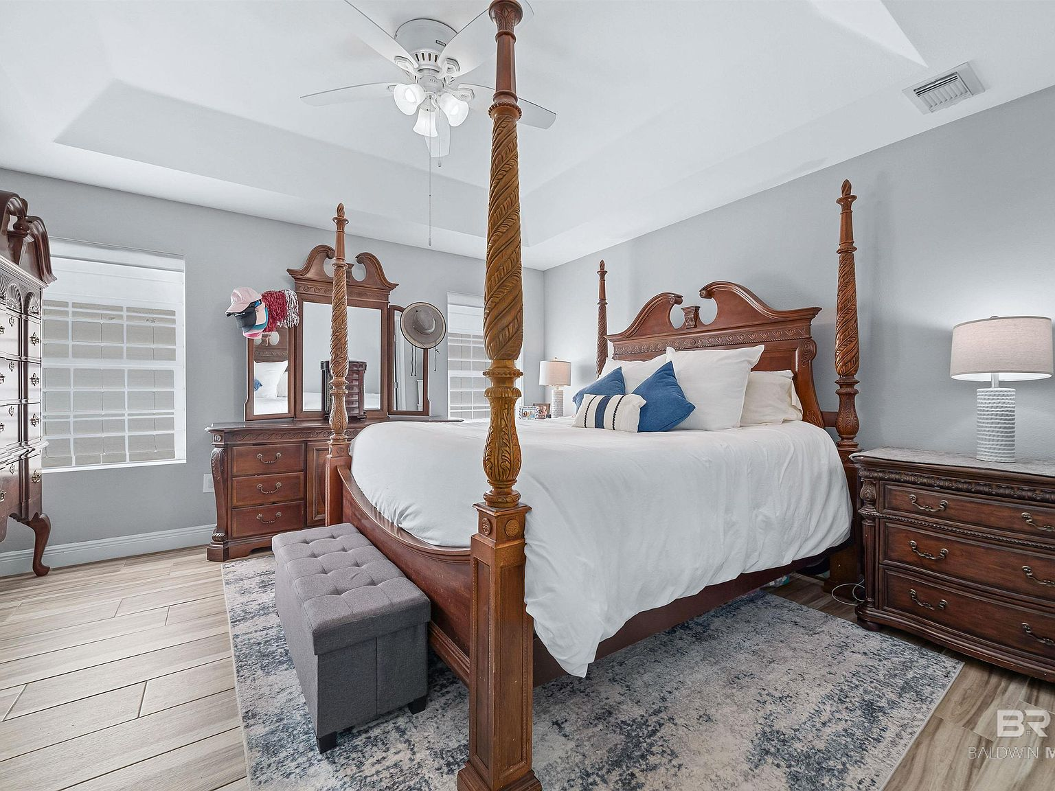 Master bedroom with tray ceiling and wood-look tile flooring