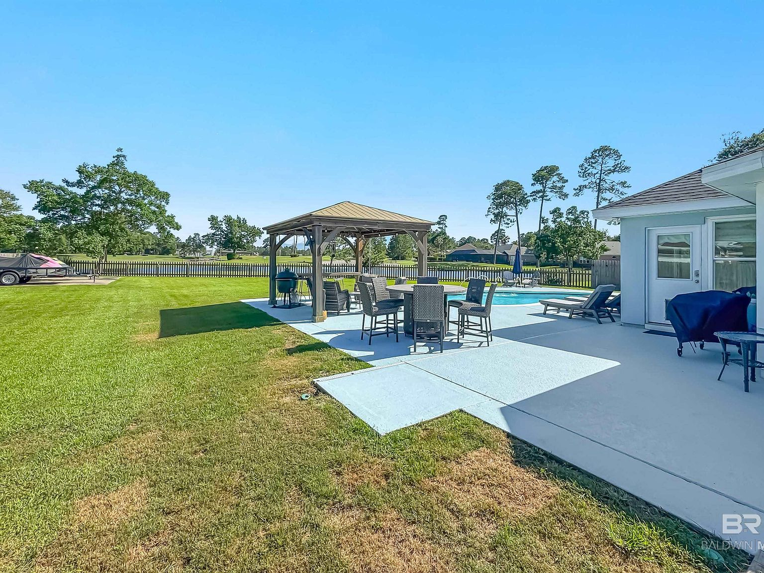 Backyard pool area with covered gazebo for grilling